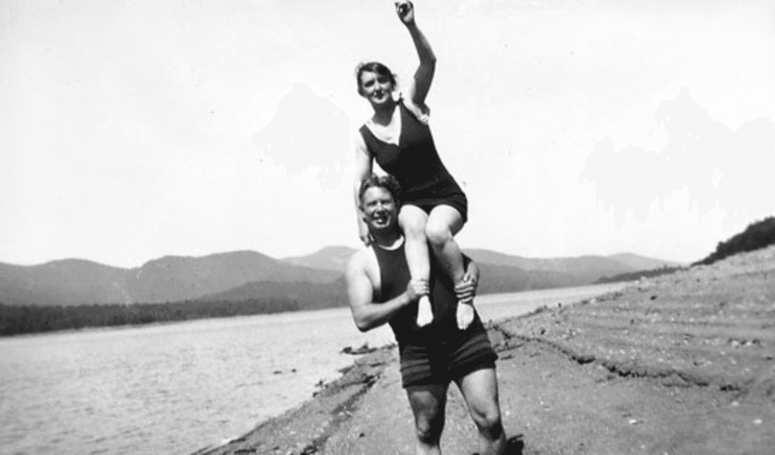 William Moulton Marston carregando Elizabeth Holloway Marston em uma paisagem de montanha.